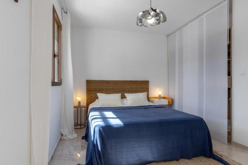 une chambre avec un lit avec une couverture bleue dans l'établissement Magadhja Fiurita - Appt climatisé - Vue mer, à Pietrosella