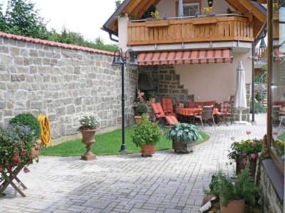 eine Terrasse mit Gartenmöbeln und ein Gebäude in der Unterkunft Pension Göppner in Bad Neustadt an der Saale