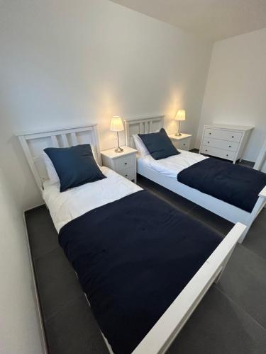 deux lits côte à côte dans une chambre dans l'établissement Maison de vacances, à Andernos-les-Bains