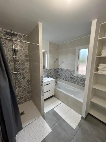 une salle de bain avec une douche, une baignoire et un lavabo dans l'établissement Maison de vacances, à Andernos-les-Bains