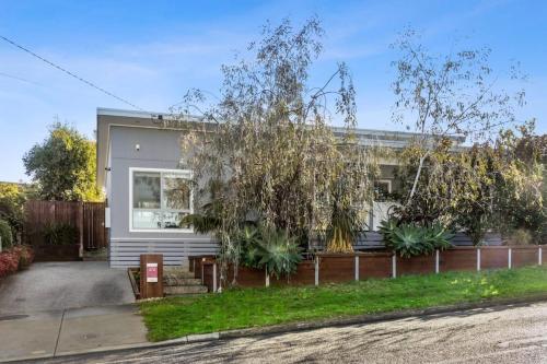 a house with a fence in front of it at Sunset Days Family Holiday House 200m to Shops in Ocean Grove