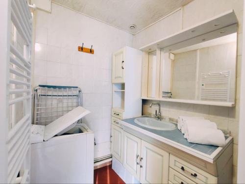 une salle de bain blanche avec un lavabo et un miroir dans l'établissement LA MAISONNETTE, à Neuvy-Saint-Sépulchre