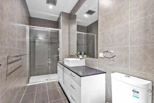 a bathroom with a shower and a sink and a toilet at Sunset Days Family Holiday House 200m to Shops in Ocean Grove