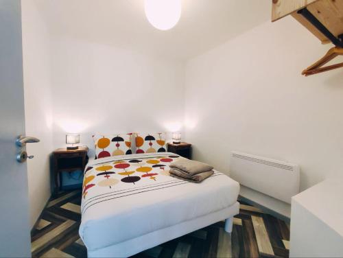 une chambre blanche avec un lit avec des fleurs dessus dans l'établissement LA MAISONNETTE, à Neuvy-Saint-Sépulchre