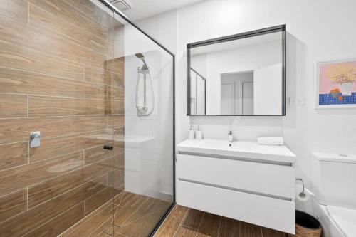a bathroom with a shower and a sink and a mirror at Boardwalk on Bright Coastal Apartment in Torquay