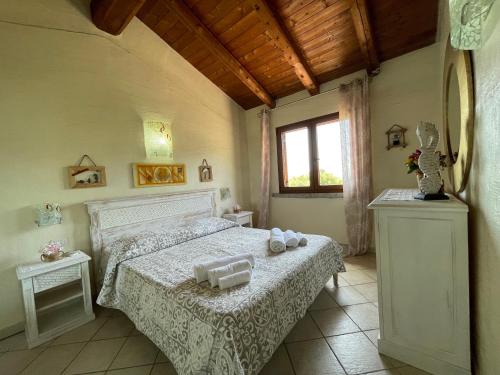 a bedroom with a bed with two towels on it at L'Incanto Tanca Piras in Nebida