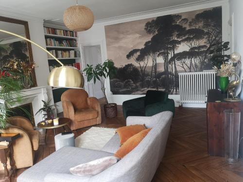 ein Wohnzimmer mit einem Sofa und Stühlen in der Unterkunft Lumière & Majesté Appartement Versailles in Versailles