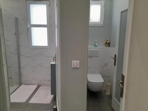 een witte badkamer met een douche en een toilet bij maison entiere au calme in Montgeron