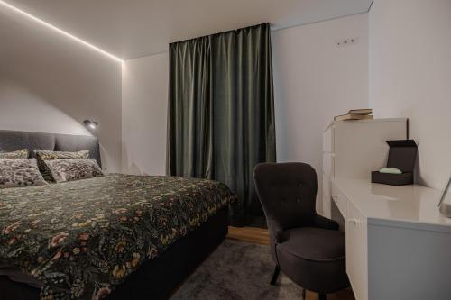 a bedroom with a bed and a desk and a chair at Fantasy House, cozzy apartmens, free parking, long stays welcome in Vilnius