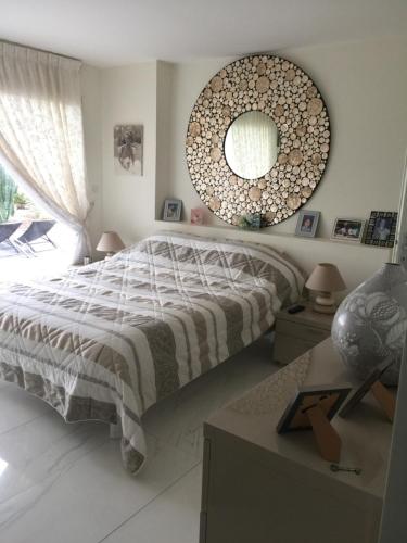 une chambre avec un lit et un miroir au mur dans l'établissement Barbicaja, à Ajaccio