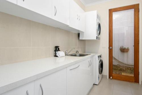 uma cozinha branca com um lavatório e uma máquina de lavar roupa em Bristol Rd Townhouse Ctr of Torquay 600m to beach em Torquay