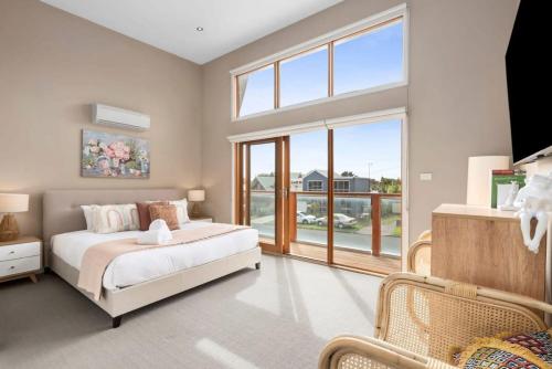 a bedroom with a bed and a large window at Over the dunes to the beach in seconds in Ocean Grove