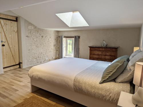 Un gîte en Charente, gîte 4 étoiles في Roullet-Saint-Estèphe: غرفة نوم بسرير كبير ونافذة