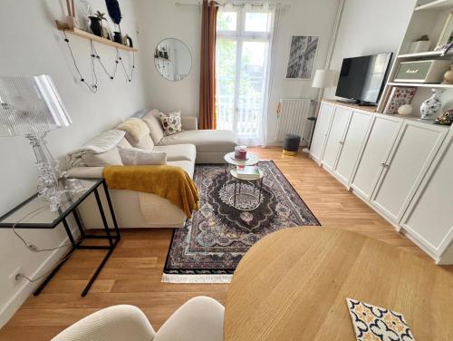 Apartment near to Paris (7 minutes) في أسنيير-سور-سين: غرفة معيشة مع أريكة وطاولة