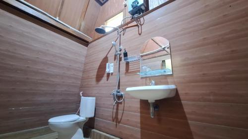 a wooden bathroom with a toilet and a sink at The Allabun Glamping Yogyakarta in Kaliurang