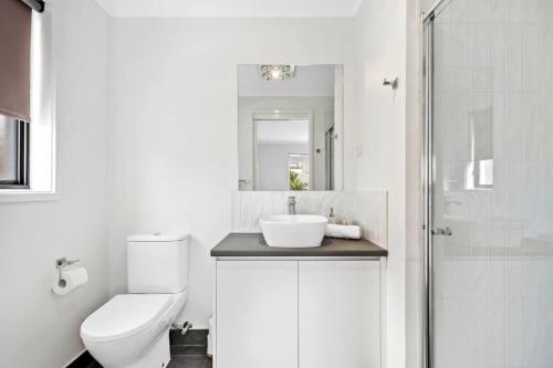 ein Bad mit einem WC, einem Waschbecken und einer Dusche in der Unterkunft Sea Breeze Coastal Beach House Pet Friendly in Ocean Grove