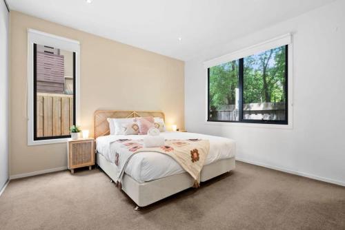 ein weißes Schlafzimmer mit einem Bett und einem Fenster in der Unterkunft Park View Coastal Oasis Barwon Heads Pet friendly in Barwon Heads