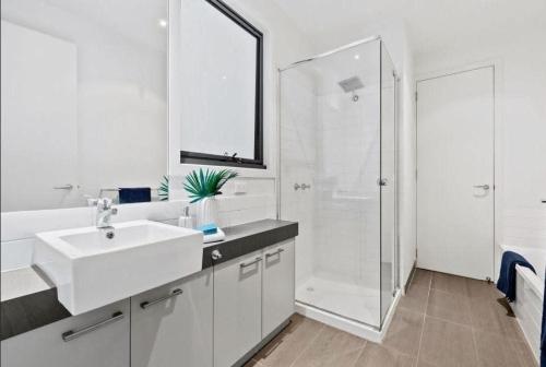 ein weißes Bad mit einem Waschbecken und einer Dusche in der Unterkunft Park View Coastal Oasis Barwon Heads Pet friendly in Barwon Heads