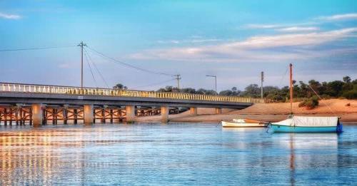 a bridge and two boats in the water with a bridge at Park View Coastal Oasis Barwon Heads Pet friendly in Barwon Heads