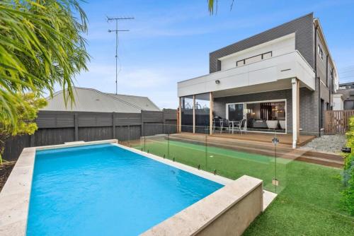 a swimming pool in the backyard of a house at Waterways Luxury Poolside Retreat in Prime Location in Ocean Grove