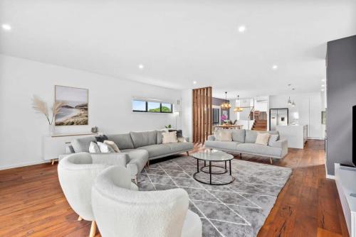 a living room with a couch and a table at Waterways Luxury Poolside Retreat in Prime Location in Ocean Grove