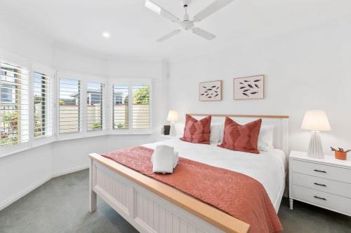 a white bedroom with a large bed and windows at Incredible Location - Steps to Torquays Cafes and Beaches - Pet Friendly in Torquay