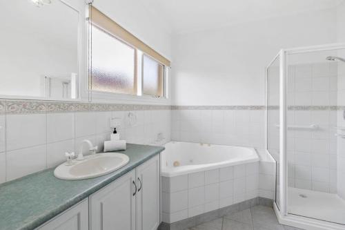 un bagno bianco con lavandino e vasca di On the doorstep of Torquays cafes and beaches a Torquay