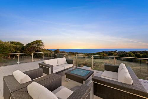 a patio with furniture and a view of the ocean at Waterline in Bellbrae