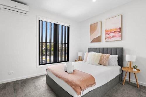 ein Schlafzimmer mit einem Bett und einem großen Fenster in der Unterkunft Torquay Central Beach Retreat in Torquay
