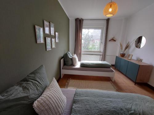 a bedroom with a bed and a window with a bench at Cozy Home, 7 Beds, WiFi, Kitchen, Balcony, Bielefeld Center in Bielefeld