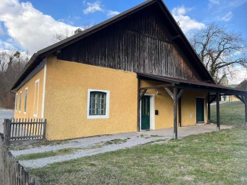 un bâtiment jaune avec un toit noir dans l'établissement 3144 Zur Alten Forstkanzlei, à Wald