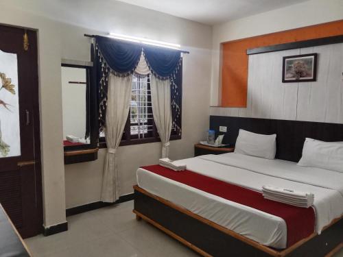 ムンナルにあるSundarms Hill Crestの大きなベッドと窓のある寝室