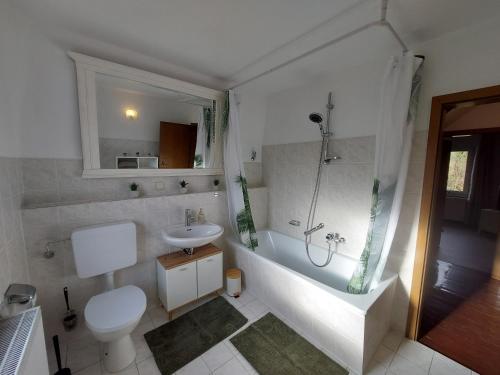 a bathroom with a tub and a toilet and a sink at Cozy Home, 7 Beds, WiFi, Kitchen, Balcony, Bielefeld Center in Bielefeld