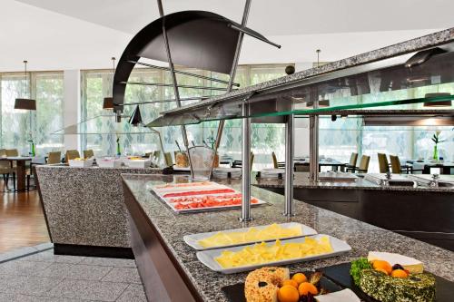 a kitchen with many different types of food on a counter at NH Mannheim Viernheim in Viernheim