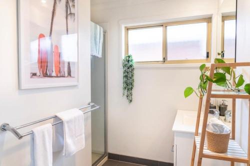 a bathroom with a towel rack and a window at Ebb and Flow Torquay pet friendly unit in Torquay