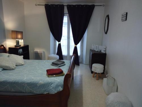 - une chambre avec un lit et une fenêtre avec des rideaux dans l'établissement L'Écluse, à Dieppe