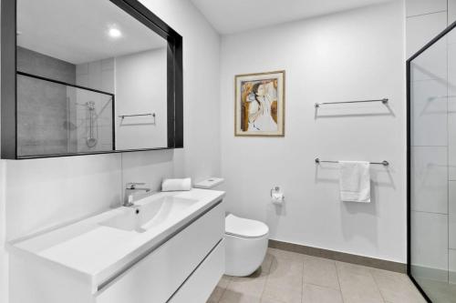 La salle de bains blanche est pourvue d'un lavabo et de toilettes. dans l'établissement Saltbush By The Park, à Torquay