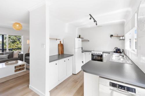 a kitchen with white cabinets and a counter top at Blue Seas Beach House, 400 metres to the beach in Ocean Grove