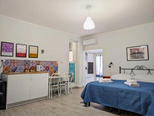 een slaapkamer met een bed en een keuken met een tafel bij La Sartoria - Casetta napoletana in Napels