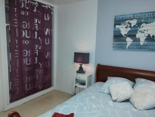 1 dormitorio con 1 cama y una foto en la pared en L'Écluse en Dieppe