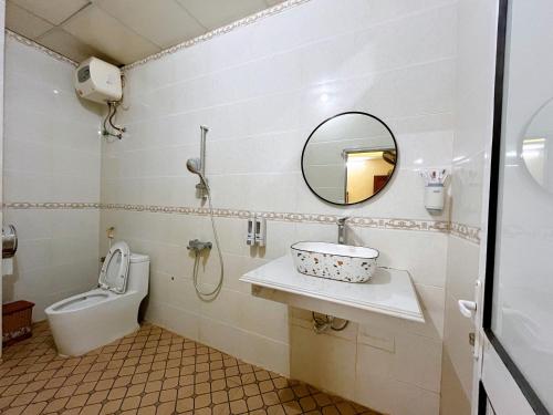 bagno con lavandino, servizi igienici e specchio di Khách sạn Đức Tài a Bảo Lạc