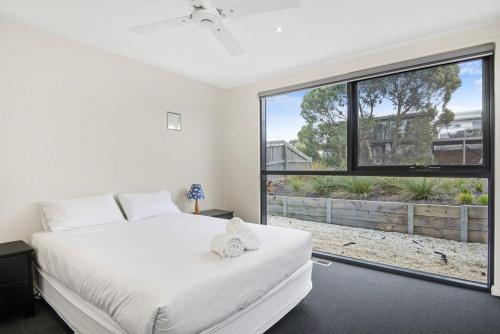 a bedroom with a white bed and a large window at Seaview Sanctuary Jan Juc Distant Ocean View in Torquay
