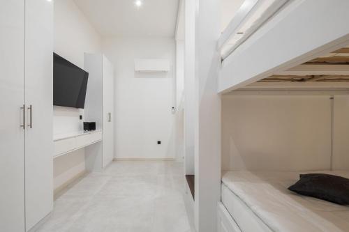 a white room with a bed and a tv at Villa royale with shared pool in Hvar