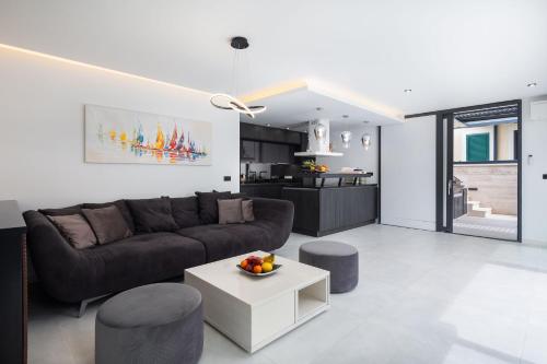 a living room with a couch and a table at Villa royale with shared pool in Hvar