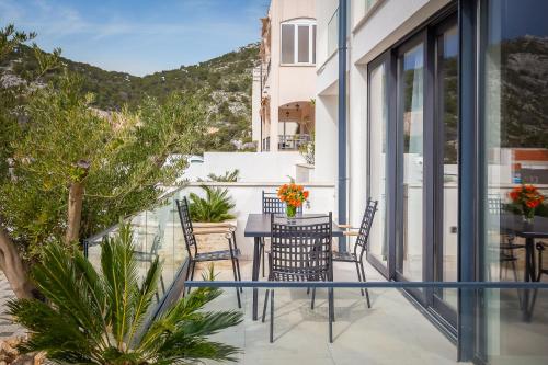 a balcony with a table and chairs on a building at Villa royale with shared pool in Hvar