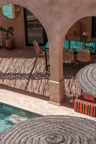 a patio with a table and chairs and a swimming pool at Villa DAR BOUMA in Ghazoua