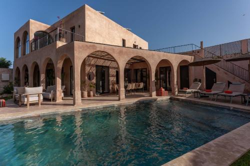 a swimming pool in front of a house at Villa DAR BOUMA in Ghazoua