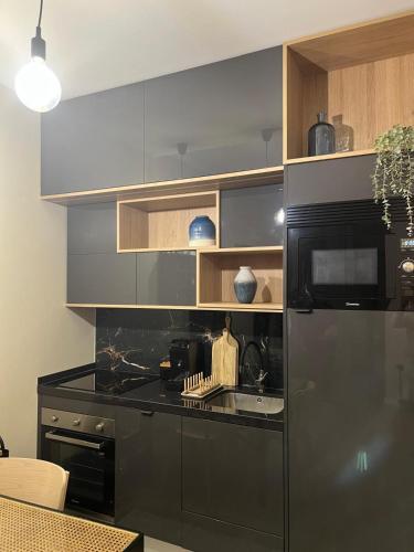 a kitchen with a stainless steel refrigerator and a sink at Casa da vila in Faro