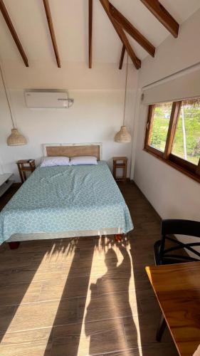 ein Schlafzimmer mit einem Bett mit einer grünen Bettdecke in der Unterkunft Villas del Mar in Las Tunas