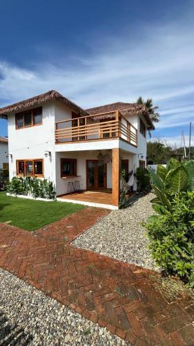 uma grande casa branca com um alpendre e um pátio em Villas del Mar em Las Tunas